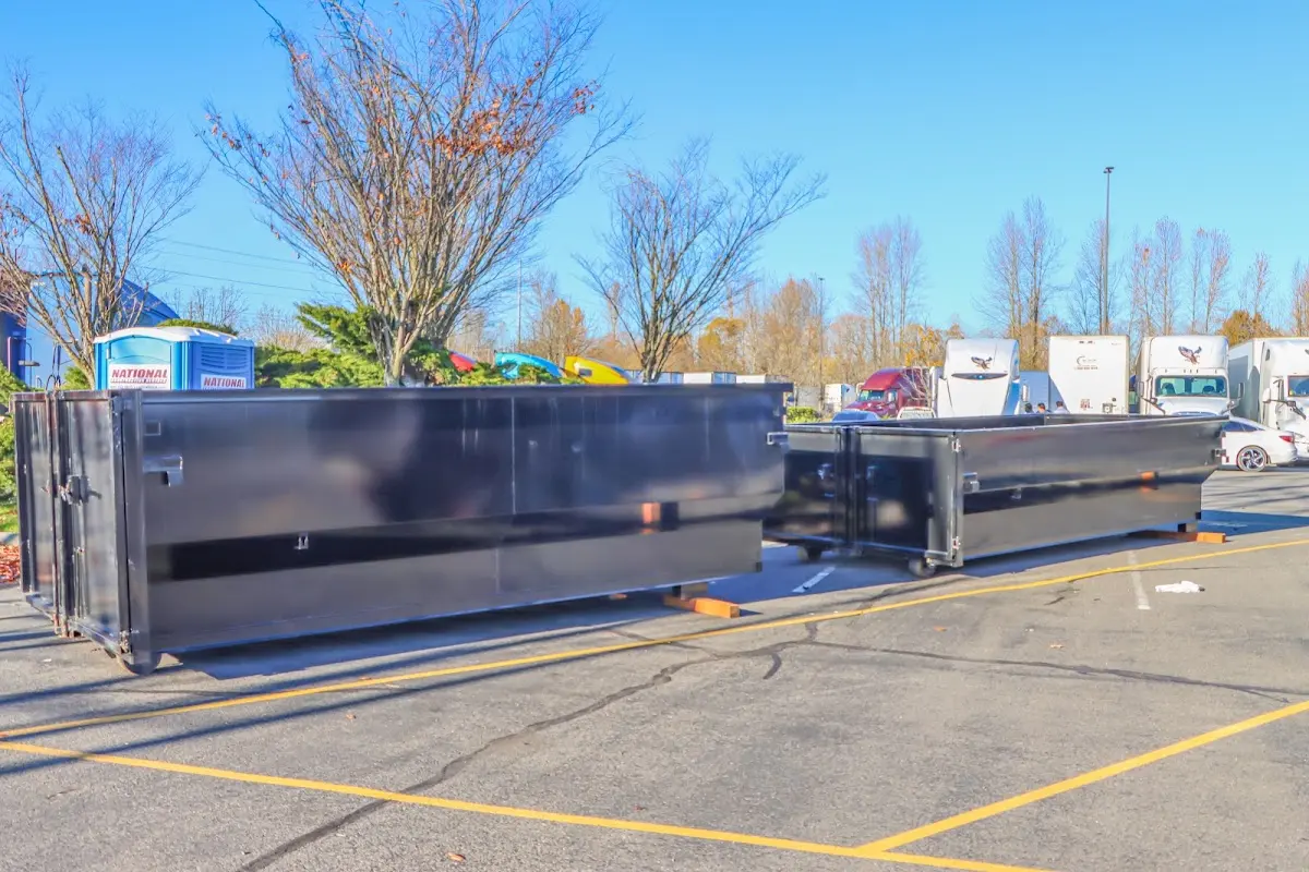 Professional dumpster rental service with roll-off container on residential driveway in Durango